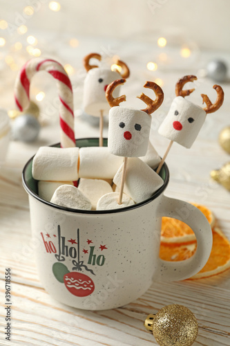 Cup with marshmallow on Christmas wooden background