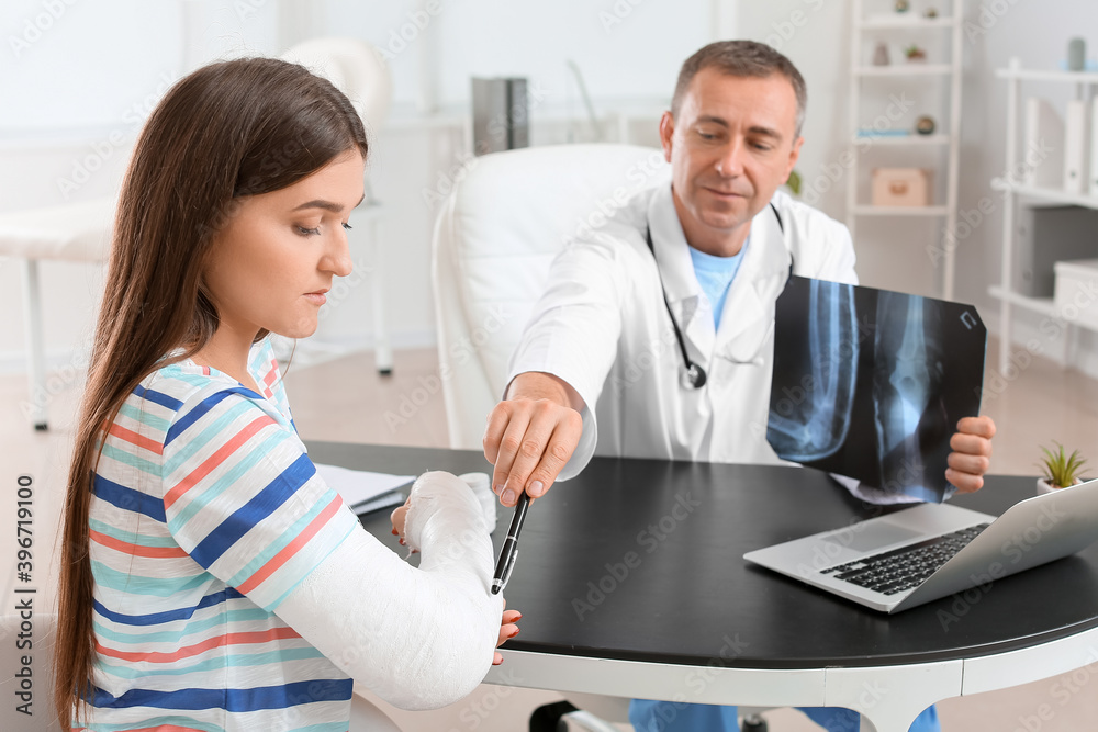 Young woman with broken arm visiting doctor in clinic Young woman with broken arm visiting doctor in clinic