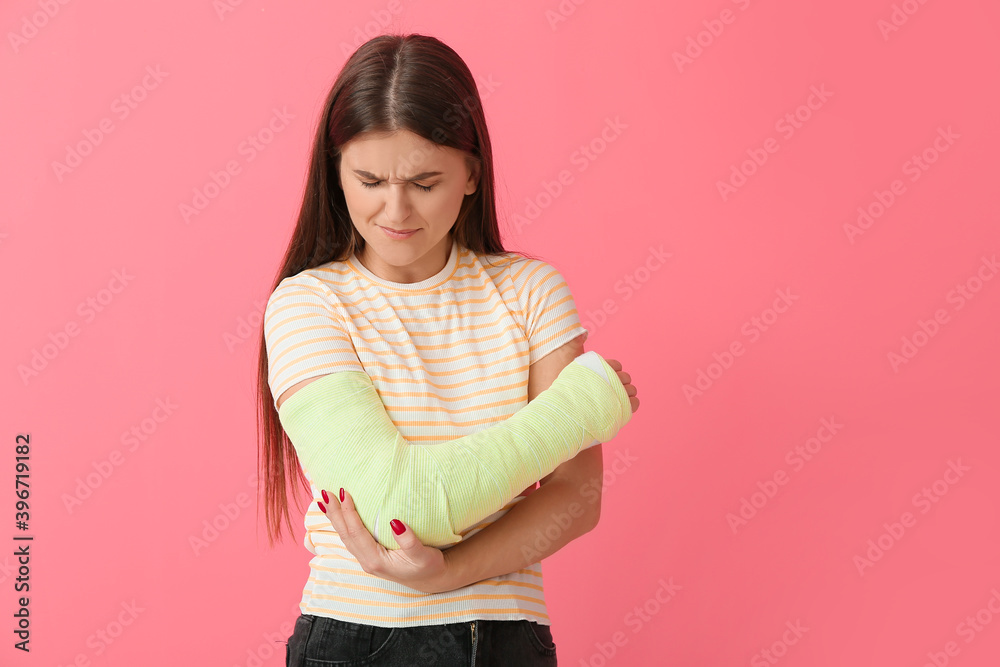 Young woman with broken arm on color background Young woman with broken arm on color background