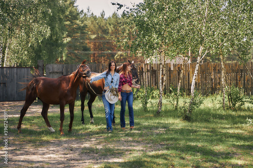 Two female cowboys lead the horses for a ride. © Aleksandr