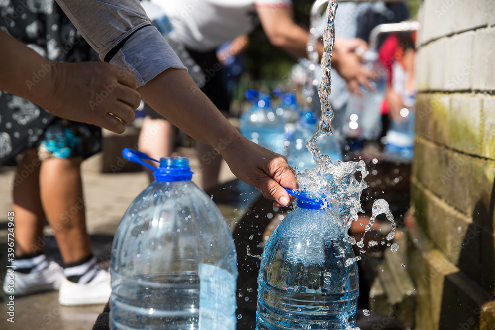 Fototapeta premium Collecting natural spring water with day zero water crisis with plastic water bottle at Newlands natural spring Cape Town South Africa with water shortage disaster.