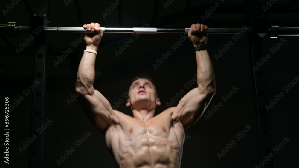 Fitness man pumping up muscle doing pull-ups exercises in gym naked torso. Handsome strong athletic men pumping up back muscles workout fitness and bodybuilding concept background Fitness man pumping up muscle doing pull-ups exercises in gym naked torso. Handsome strong athletic men pumping up back muscles workout fitness and bodybuilding concept background