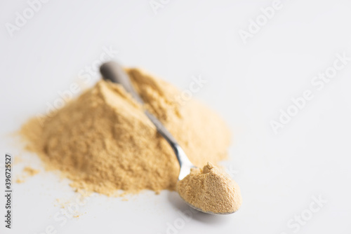 Foto Lecithin heap with a spoon on a light background.