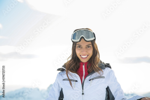 Smiling young woman wearing ski goggles