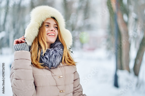 Laughing woman in winter clothes in the park.