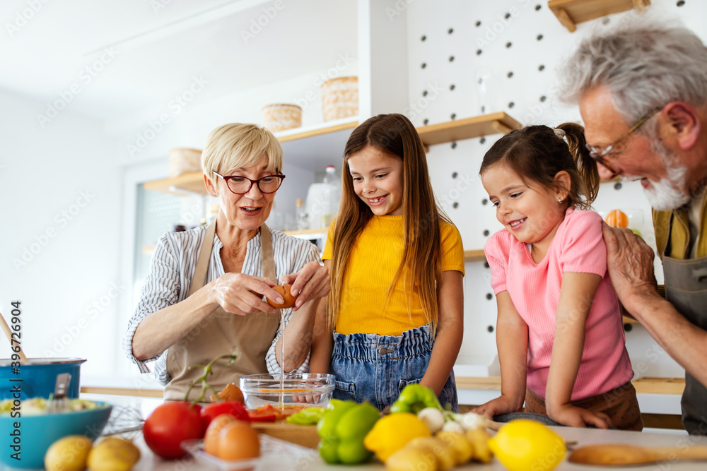 Happy senior couple having breakfast with their grandchildren at home Happy senior couple having breakfast with their grandchildren at home