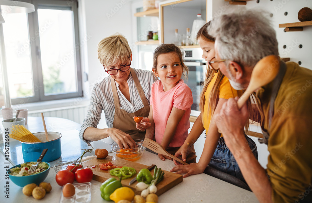 Happy senior couple having breakfast with their grandchildren at home