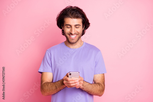 Portrait of young person in good mood write share blog post violet t-shirt isolated on pink color background © deagreez