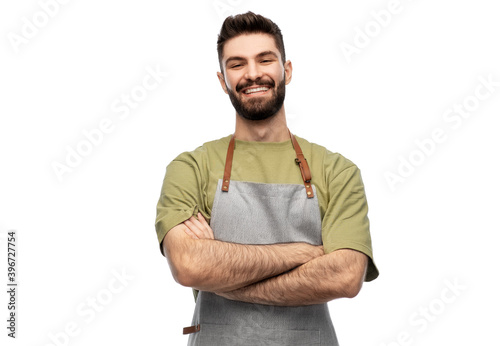 people, profession and job concept - happy smiling barman in apron with crossed arms over white background