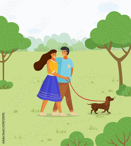 In love couple of young girl and guy wallking with dog at leash in summer park, happy people spend time together outdoors at nature with domestic pet, leisure activity, green trees and bushes