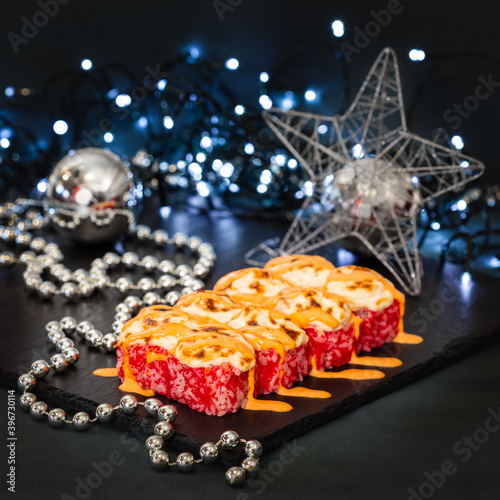 Happy New Year and Christmas celebrations. Original design of the table in the dining room with freshly prepared japanese cuisine sushi and rolls. Christmas eve