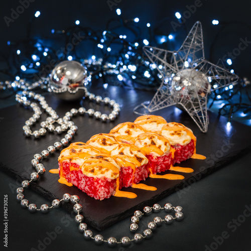 Happy New Year and Christmas celebrations. Original design of the table in the dining room with freshly prepared japanese cuisine sushi and rolls. Christmas eve