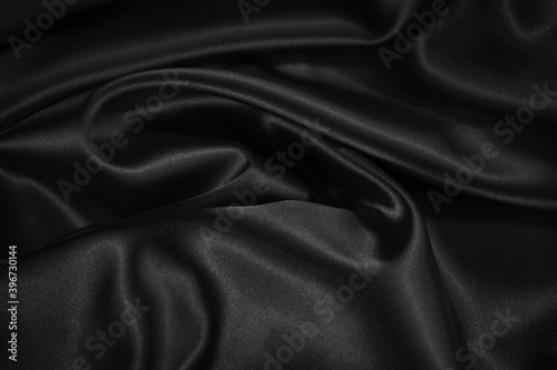 Black white background. Beautiful satin texture background. Black shiny smooth wrinkled fabric surface.