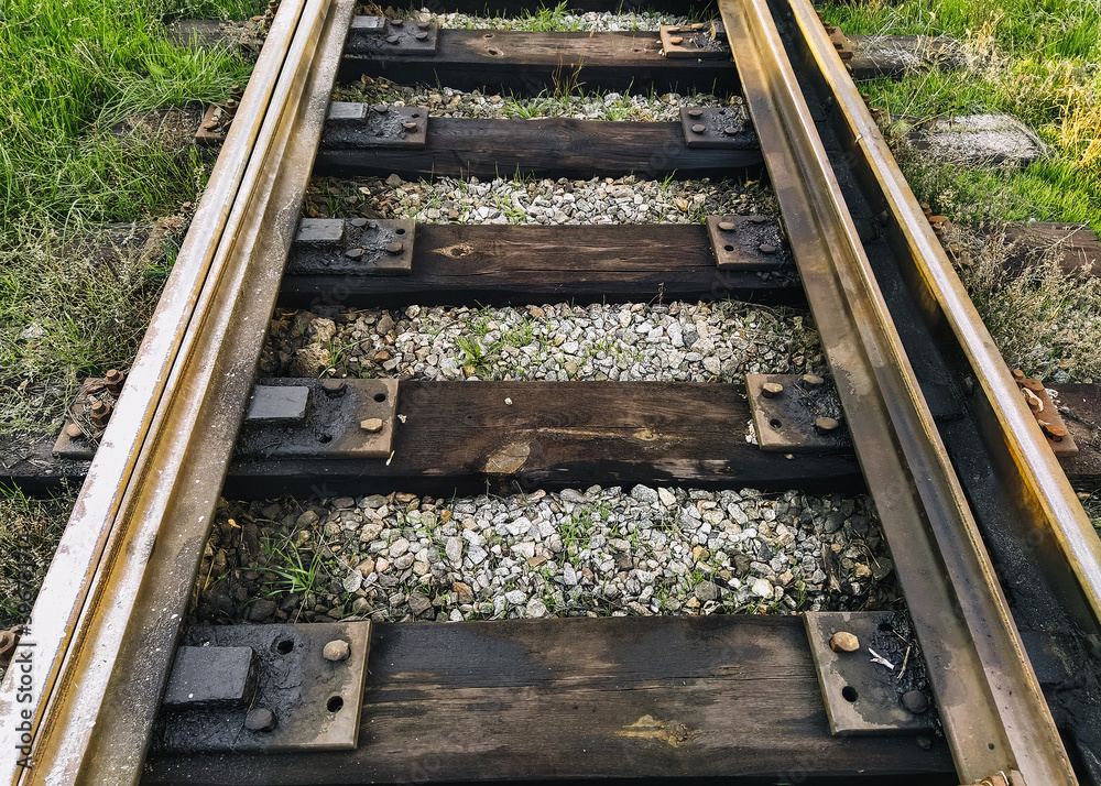 Dirty, oiled rails and wooden sleepers on the railroad. Photo, top view. Dirty, oiled rails and wooden sleepers on the railroad. Photo, top view.