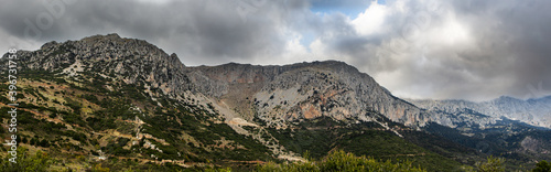 Mount Parnassus with green hills and cloudy moody skies, scenic background.