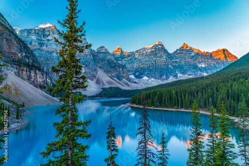 Moraine lake sunrise time in summer sunny day. Snow-covered Valley of the Ten Peaks turning red and reflect on turquoise color water surface. Landscape in Banff National Park, Alberta, Canada.