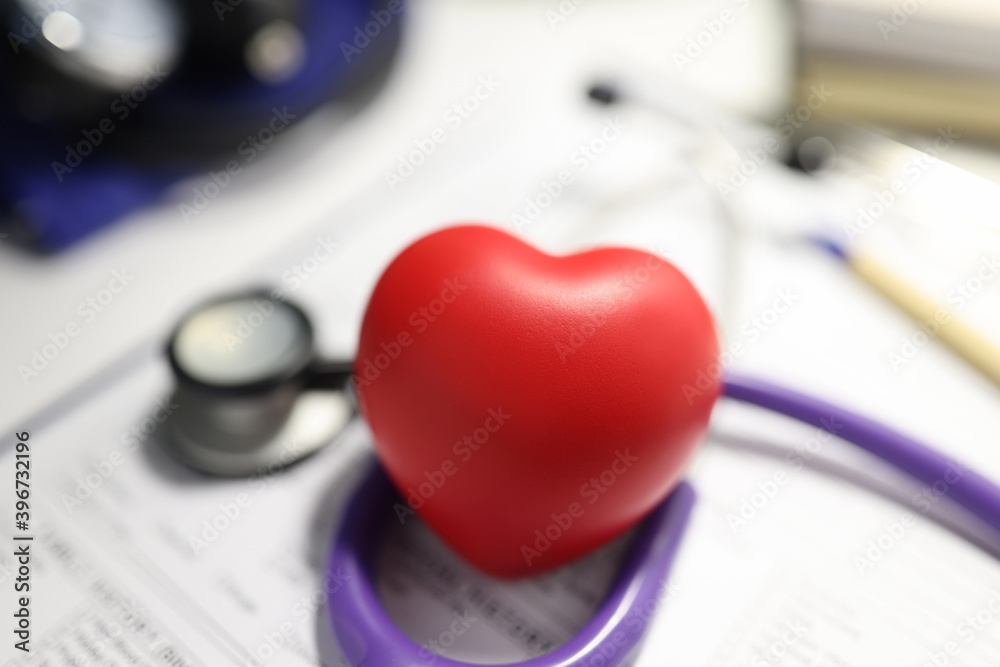 Stethoscope and red heart on table in the medical office. Stethoscope and red heart on table in the medical office.