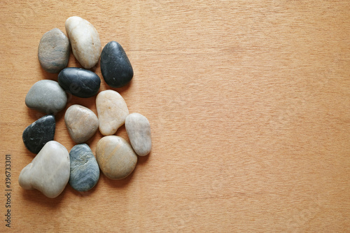 ラワン材の背景に置いた小石のグループ。平置きの俯瞰撮影。