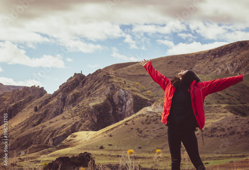 Woman stands on the edge and admires dramaic landsacape of caucasus in Vardzia. Georgia. Solo freedom and travel blogging. photo