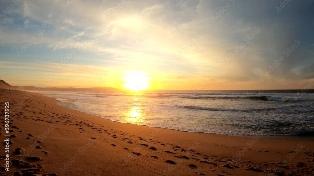 California sunset beach scenery. POV of person walking alone on the sand along a dreamy coastal sunset background. Fort Ord State Beach, California (USA).