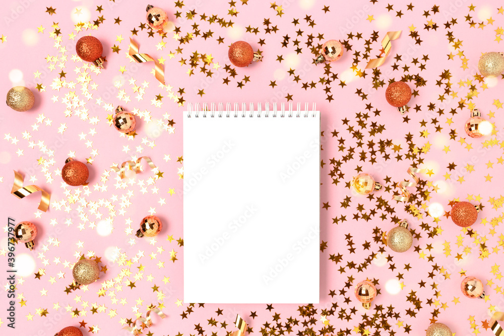 Notebook mockup on a pink background with gold confetti and Christmas baubles. Festive flatlay with place for text. Notebook mockup on a pink background with gold confetti and Christmas baubles. Festive flatlay with place for text.