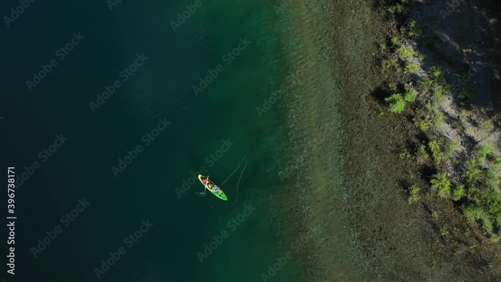 Aerial top down of two trained fishers catching trouts with dry fly technique near the shore in Lake Steffen, Patagonia Argentina. Aerial top down of two trained fishers catching trouts with dry fly technique near the shore in Lake Steffen, Patagonia Argentina.