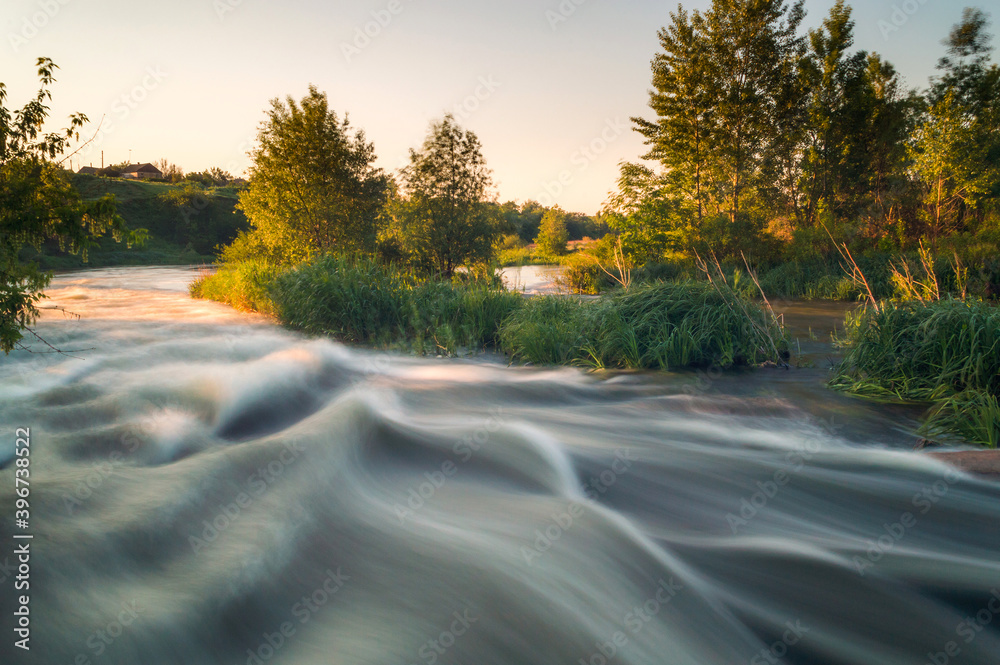 Fototapeta premium Rough river with fast-flowing in the fog and mist on the background
