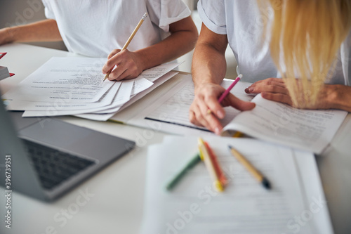 Two people with pencils working with documents photo