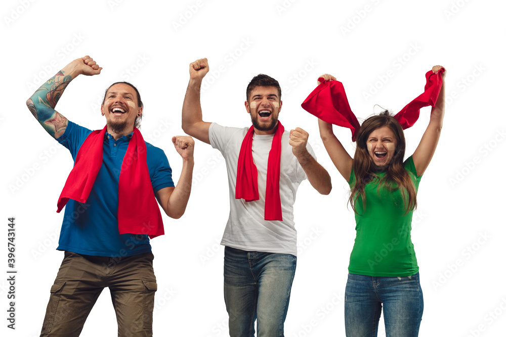 Fototapeta premium Excellent goal. Three soccer fans woman and men cheering for favourite sport team with bright emotions isolated on white studio background. Looking excited, supporting. Concept of sport, fun, support.