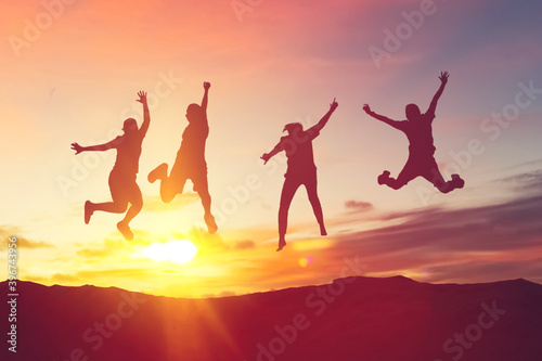 Silhouette friends jump and birds fly on sunset sky at top of mountain abstract background.