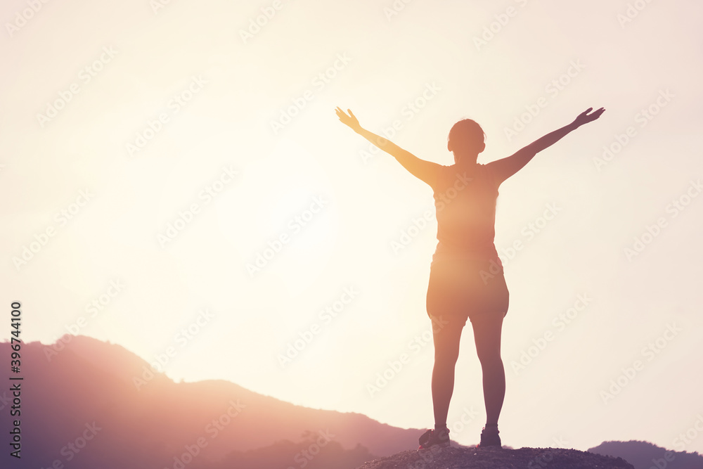 Obraz premium Copy space of woman rise hand up on top of mountain and sunset sky abstract background.