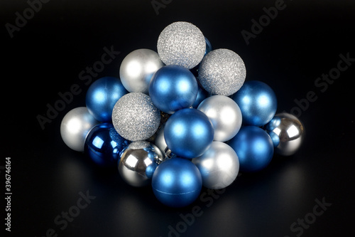 Composition from a blue and silver shiny and matte christmas balls close up view on black background