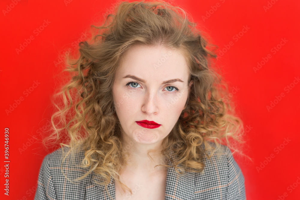 Frustrated Young blonde woman with red lips looking at camera over red background. Expressive facial emotions, lack of sleep concept Frustrated Young blonde woman with red lips looking at camera over red background. Expressive facial emotions, lack of sleep concept