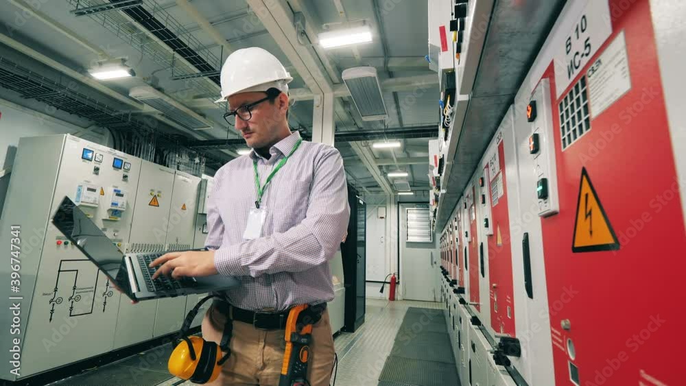 Electrician monitoring power station using his laptop. Solar energy concept. Electrician monitoring power station using his laptop. Solar energy concept.