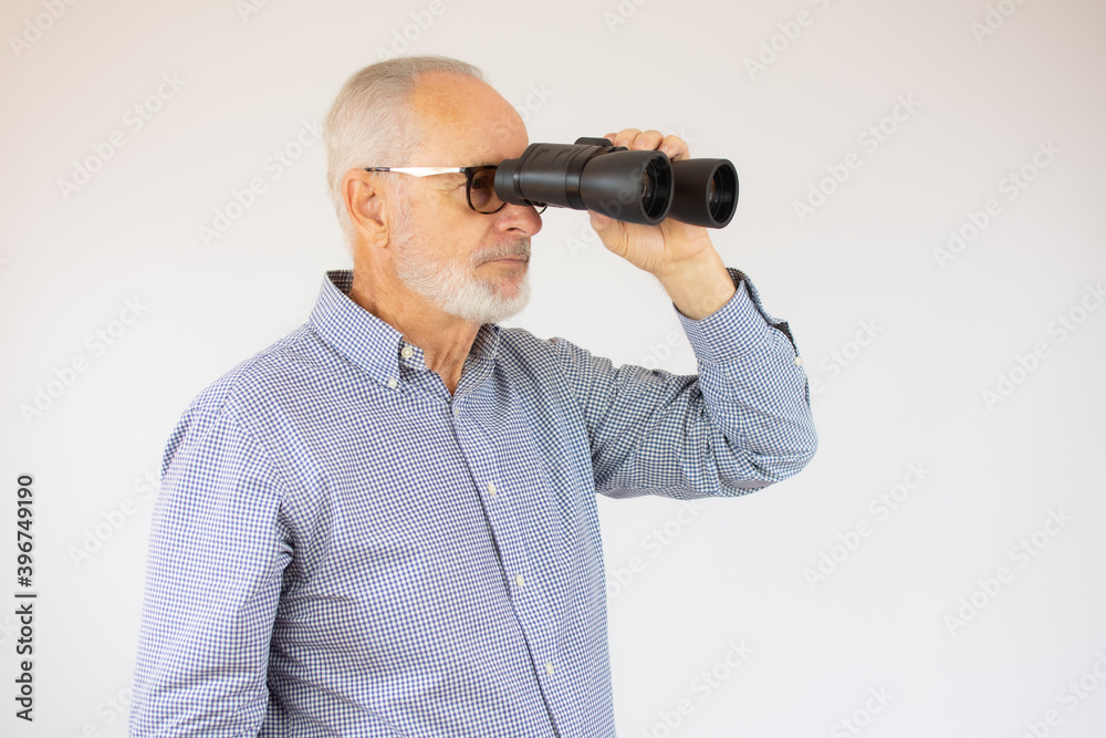 Senior man looking upward with an pair of binoculars, copy space included. Senior man looking upward with an pair of binoculars, copy space included.