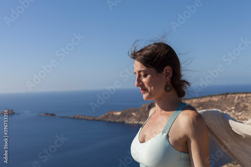 Fototapeta Naklejka Na Ścianę i Meble -  A yoga teacher teaching her student on the top of a cliff. The teacher corrects and teaches yoga poses to the student