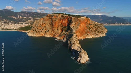 Alanya town panorama and Taurus Mountains overwashed by Mediterranean sea. Moving copter back. Antalya Province in Turkey. Slow motion, 4k. photo