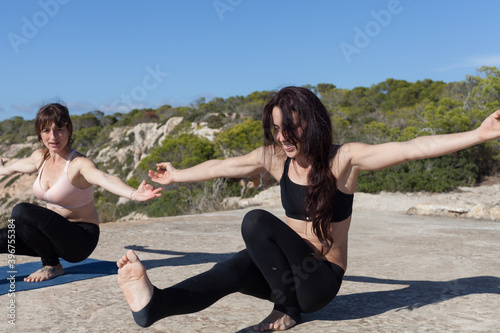 A yoga teacher holding a heart-shaped stone in her hands. The woman is in contact with the earth and prepares to meditate