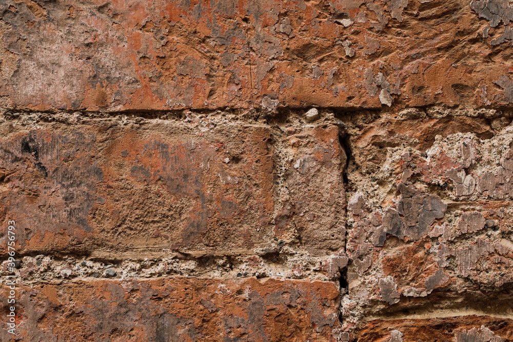 Red brick stone wall with uneven and crushed stones, stones background with space for text
Red brick stone wall with uneven and crushed stones, stones background with space for text