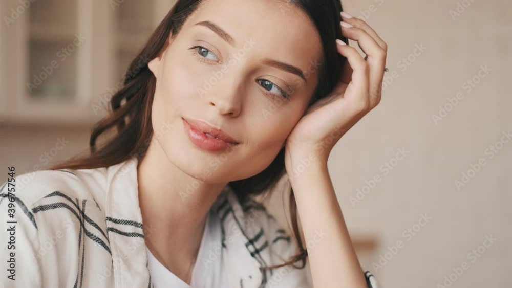 Smiling brunette woman posing at the kitchen indoors at home Smiling brunette woman posing at the kitchen indoors at home
