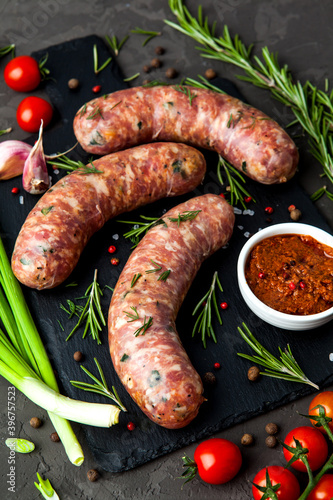 Bavarian or Munich hot sausages with seasonings and sauces on a stone board.