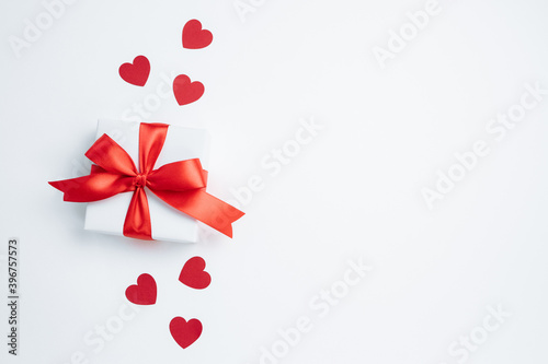 Gift box with red ribbon and hearts on white background. Valentines day banner with free space. Top view  flat lay.