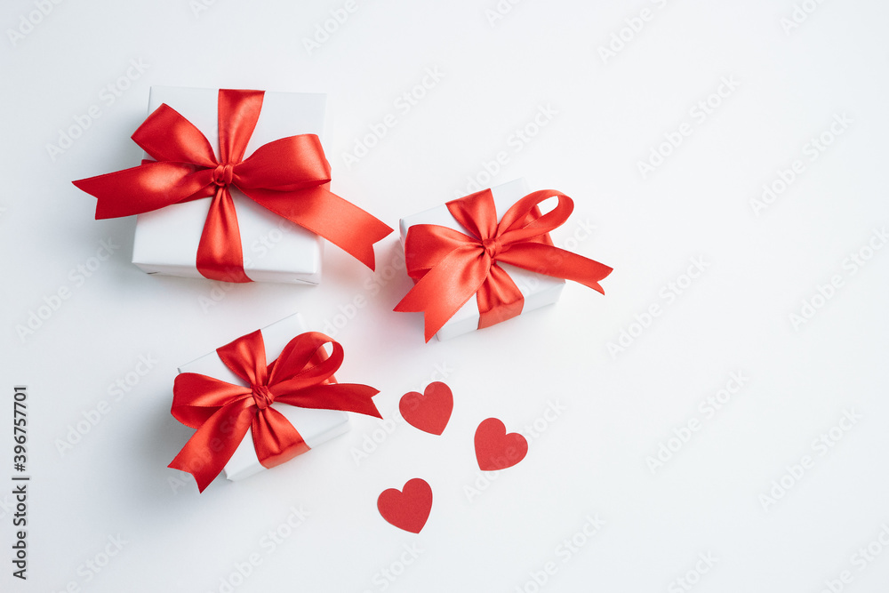 Gift boxes with red ribbon and hearts on white background. Valentines day banner with free space. Top view, flat lay. Gift boxes with red ribbon and hearts on white background. Valentines day banner with free space. Top view, flat lay.