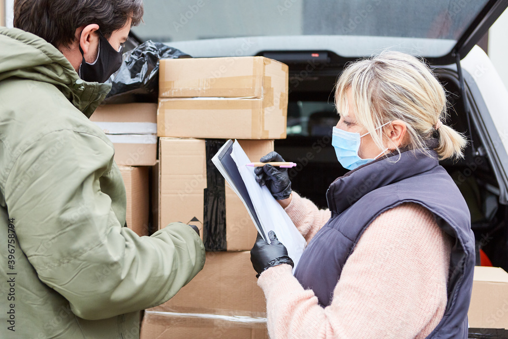 Parcel service team checks deliveries in front of an open loading space ...