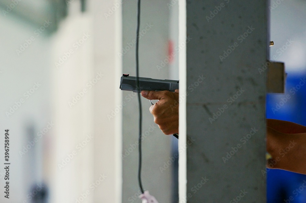 law enforcement aim pistol by two hand in academy shooting range in flare and vintage color, focus at rear gun sight law enforcement aim pistol by two hand in academy shooting range in flare and vintage color, focus at rear gun sight