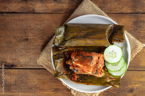 Pepes bandeng tanpa duri is Indonesian traditional food, the thornless milkfish wrapped in banana leaves is steamed and then grilled. photo