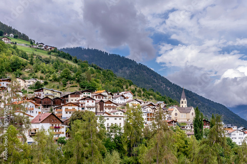 Panoramic view of the town of Stelvio, South Tyrol, Italy, with a dramatic sky in the background photo