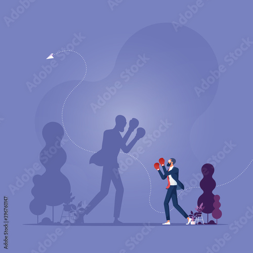 Fight your fears, win yourself, Businessman holding fists with Boxing gloves ready to fight himself as a shadow projection, Facing fears against his shadow