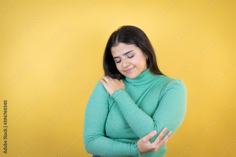 Young caucasian woman over isolated yellow background hugging oneself happy and positive, smiling confident Young caucasian woman over isolated yellow background hugging oneself happy and positive, smiling confident