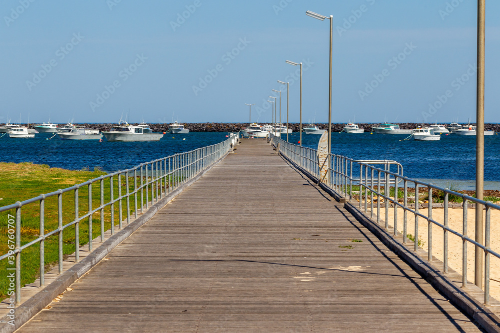 The Port MacDonnell jetty with commercial fishing boats in the background taken in South Australia on November 10th 2020